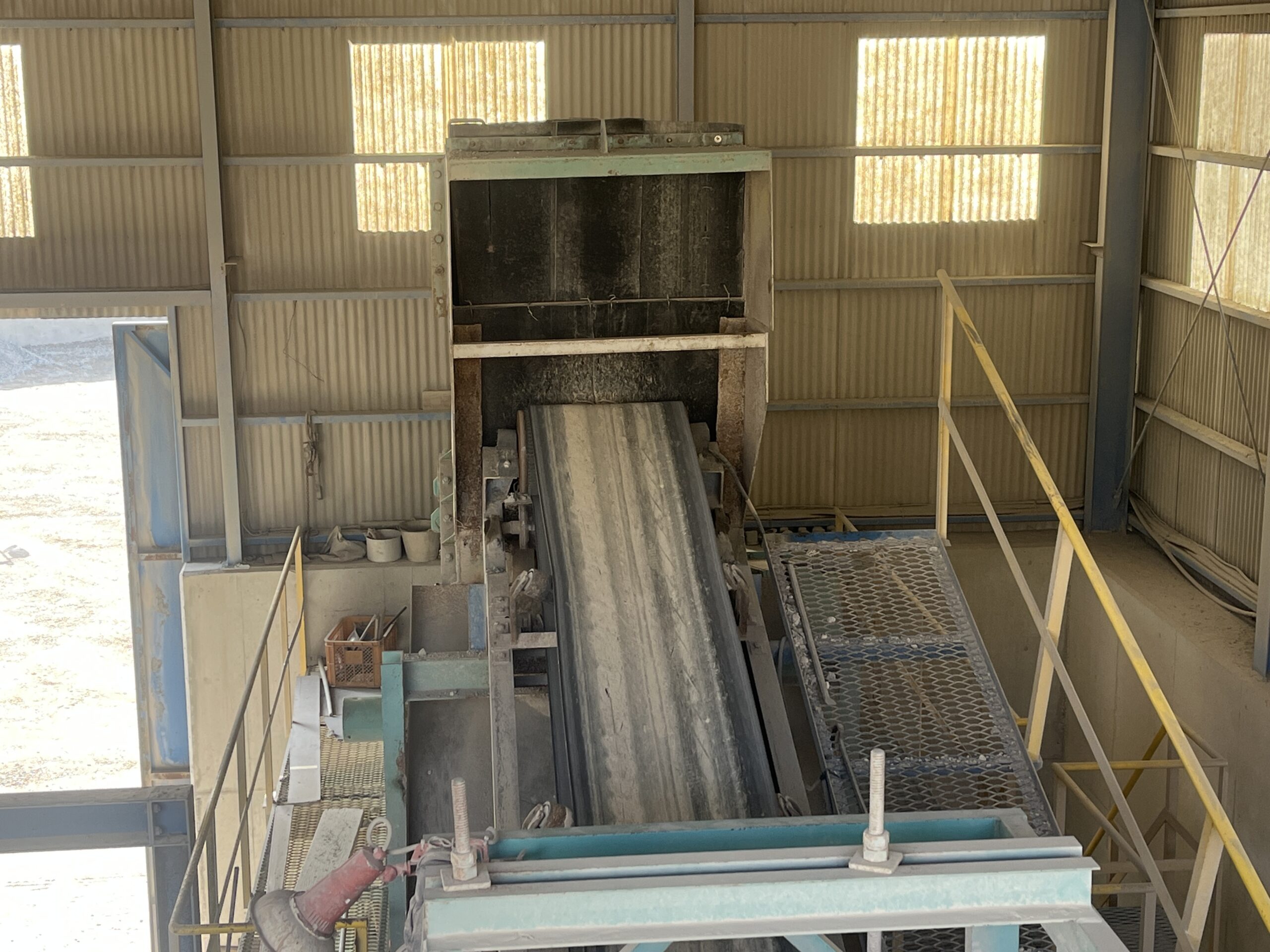 破砕機棟内部のベルトコンベアと搬送設備。廃材の粒度を均一に揃えるための処理ラインの様子